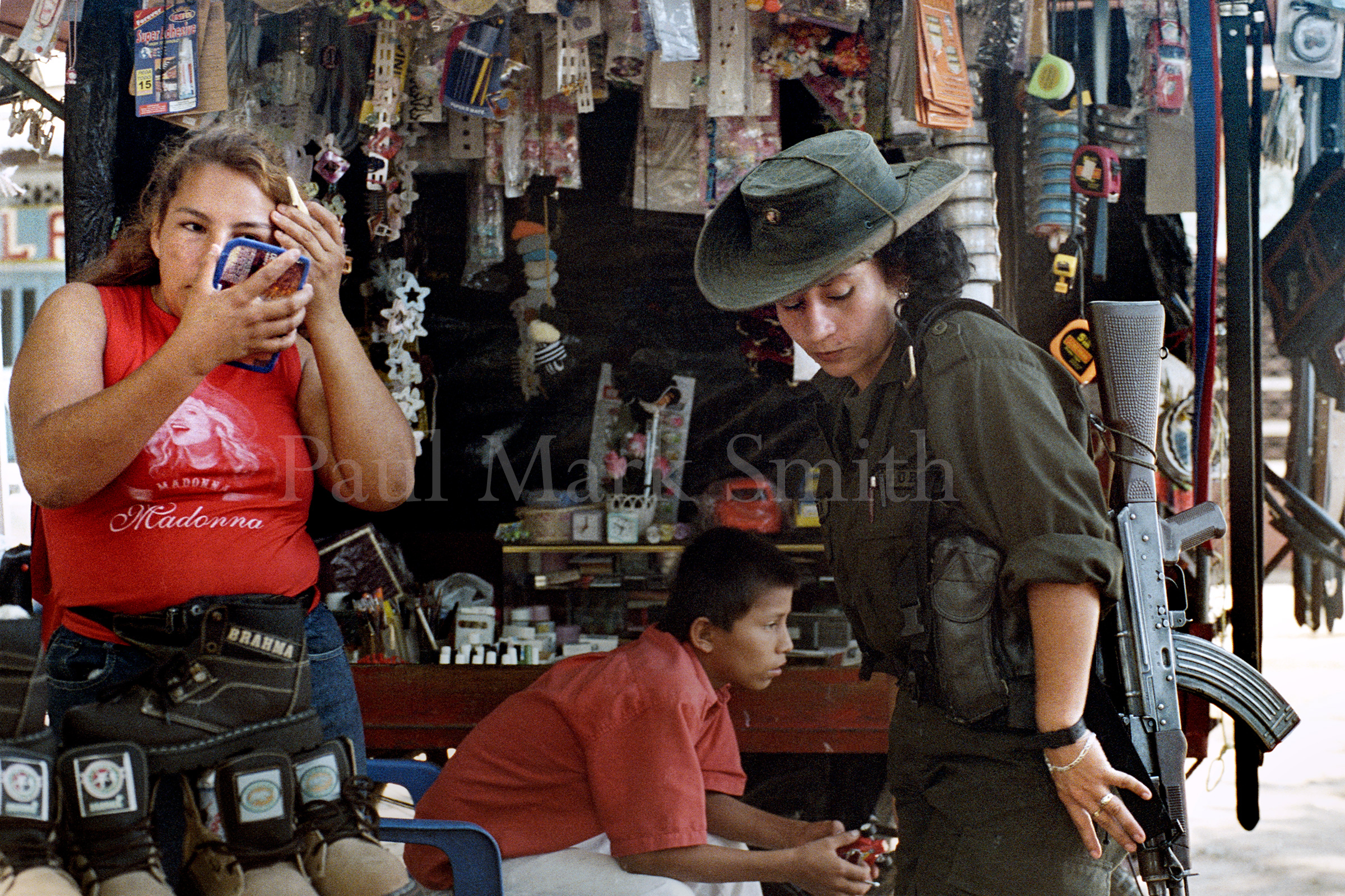 A FARC guerrilla woman and woman street vendor with a Madonna t-shirt.