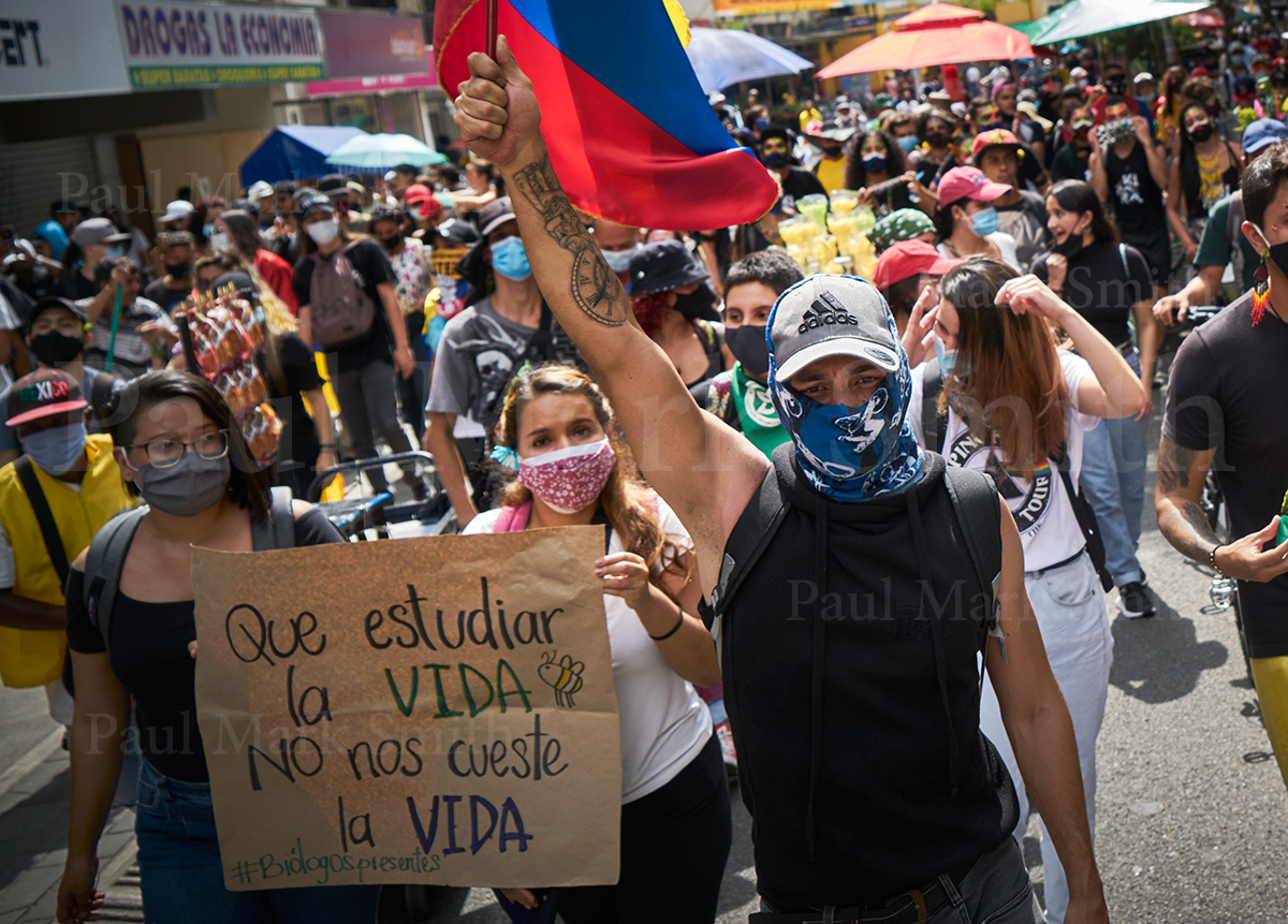 Women with placard and man with Colombian flag